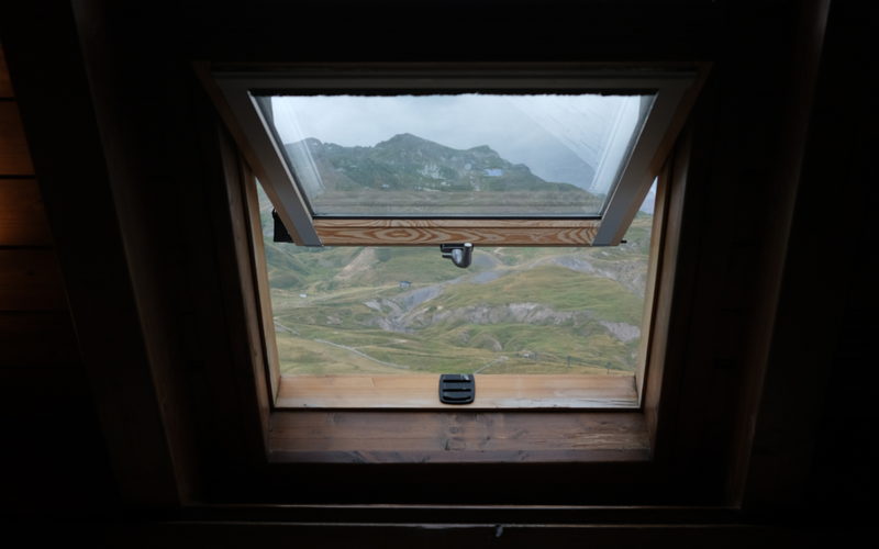 Fenêtre de toit vue depuis les combles, ouverte sur le paysage