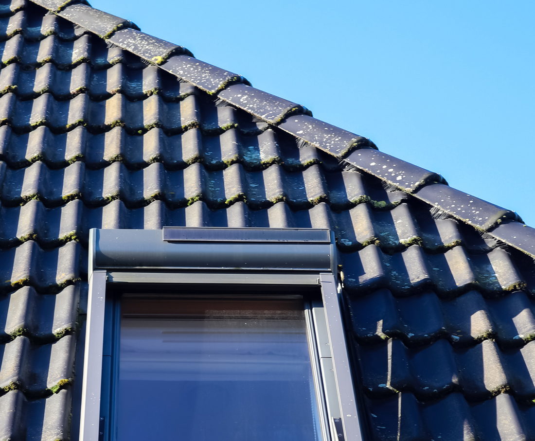 Fenêtre de toit posée dans une couverture en tuiles noires par RPS Toiture