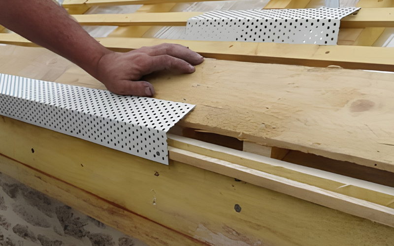 Grille de ventilation posée en bas de pente pour laisser respirer la sous-toiture