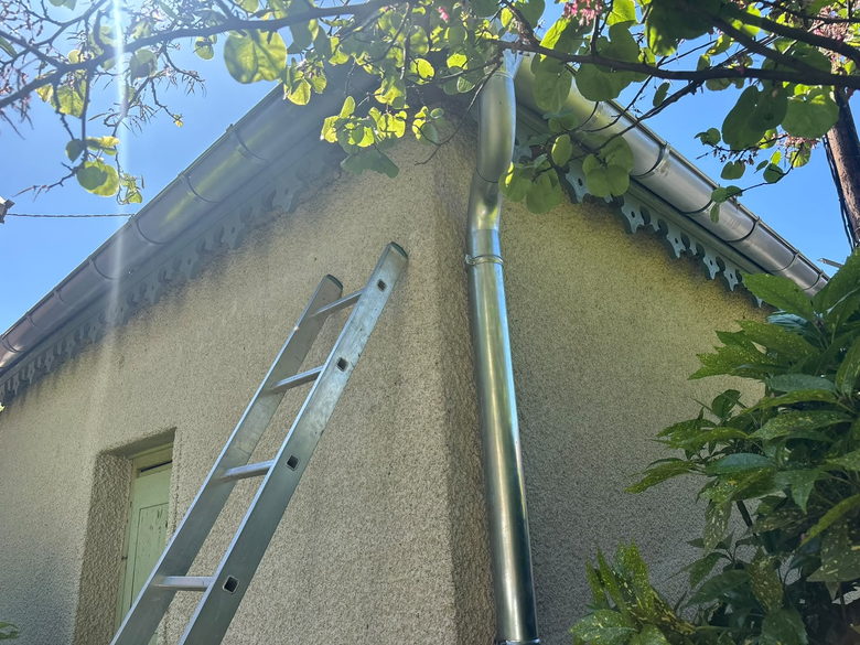 Descente de gouttière contrôlée à l'échelle le long d'un mur