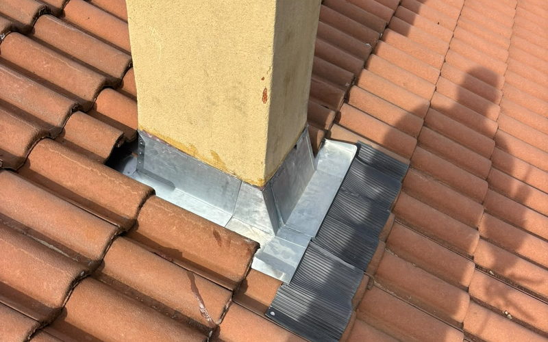 Solin en zinc neuf posé autour d'une souche de cheminée crépie