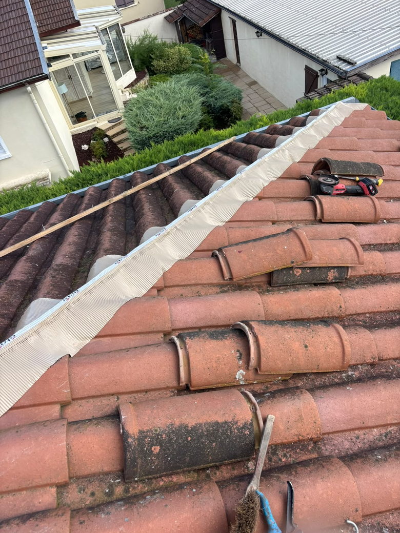 Closoir ventilé déroulé le long du faîtage avant la pose des tuiles faîtières