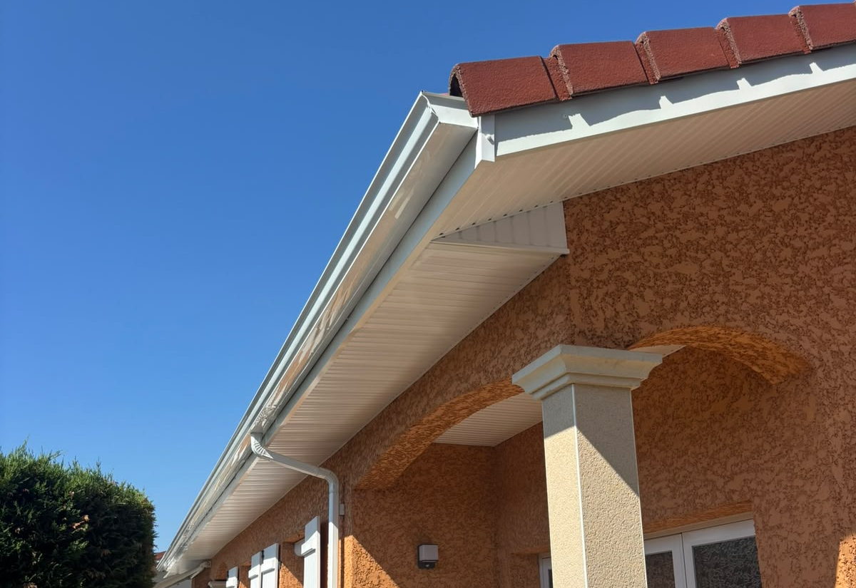 Sous-face de débord de toit habillée en PVC blanc, gouttière et descente en aluminium