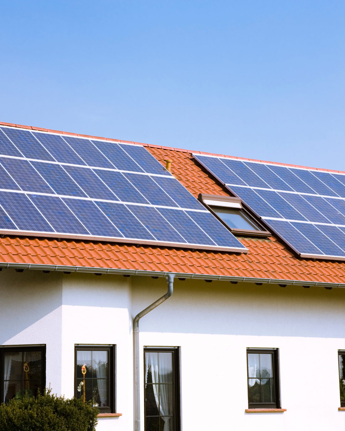 Panneaux solaires alignés sur la toiture en tuiles d'une maison individuelle